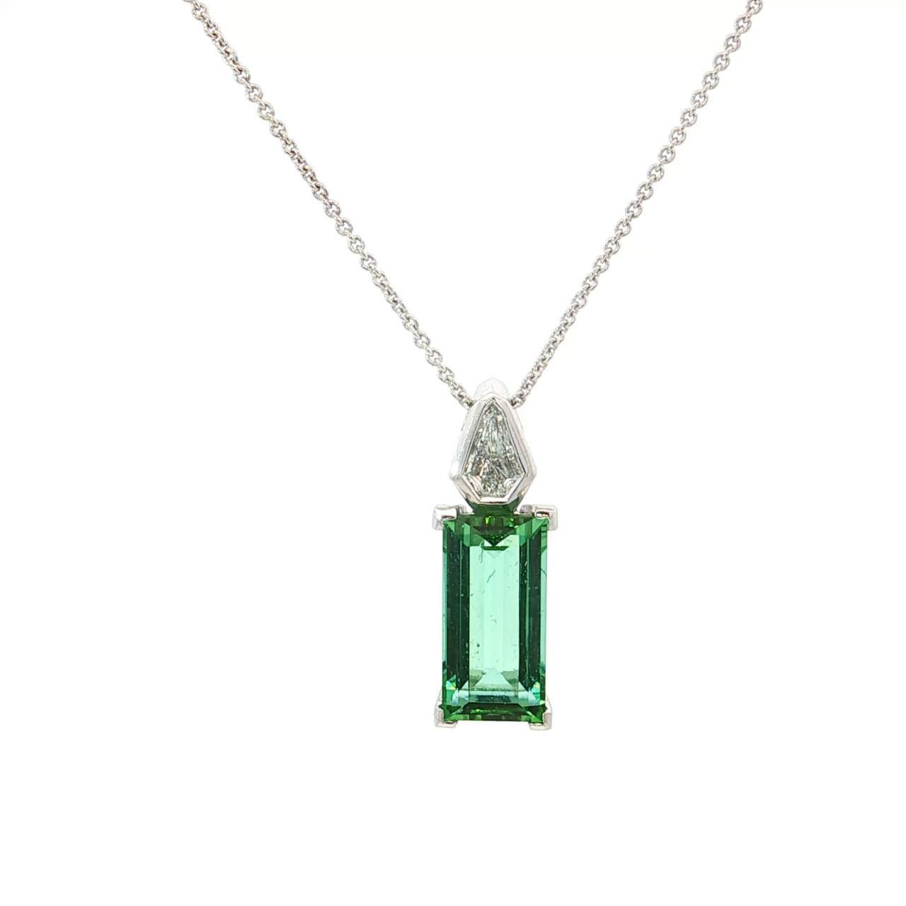 18ct white gold pendant featuring a 4.24ct rectangular cut green tourmaline and bezel-set shield diamond on a fine trace link chain.