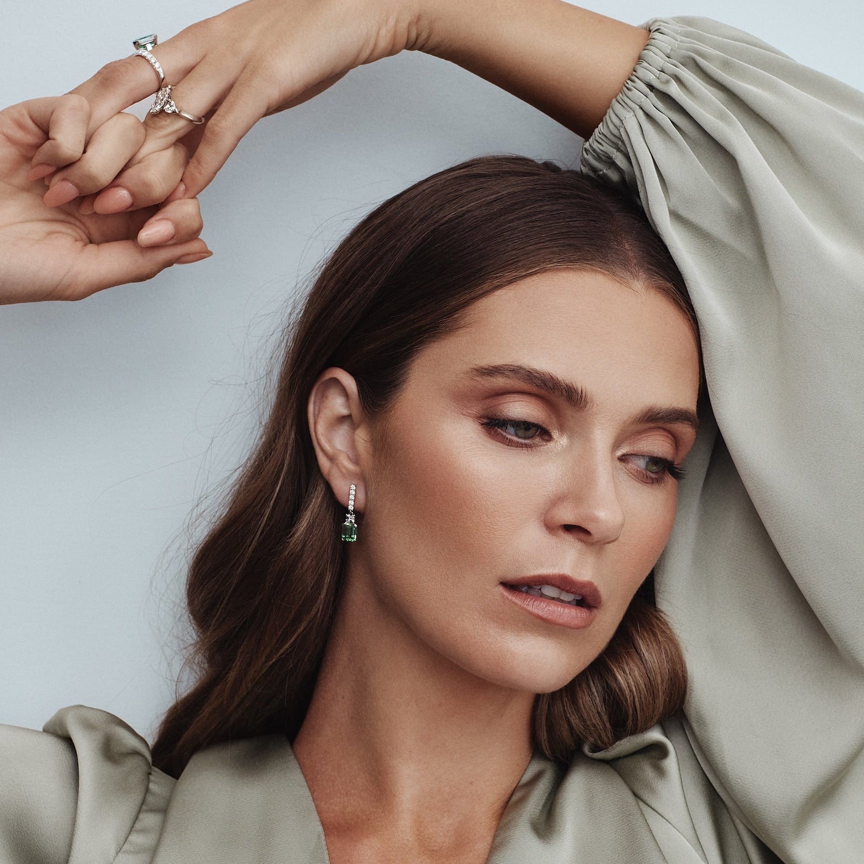 18ct white gold drop earrings featuring emerald-cut green tourmalines with diamond-set bar tops, carré cut accents, and articulated four-claw drops.