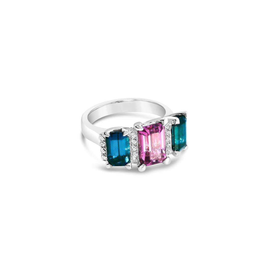 18ct white gold ring featuring a 2.11ct emerald cut purple-pink Malaia garnet with two greenish-blue tourmalines and diamond-set tiered claw and bar details.