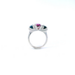 18ct white gold ring featuring a 2.11ct emerald cut purple-pink Malaia garnet with two greenish-blue tourmalines and diamond-set tiered claw and bar details.