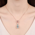 18ct rose and white gold pendant featuring pear-cut morganite and aquamarine with a central diamond accent and concealed pendant runner.