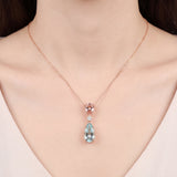 18ct rose and white gold pendant featuring pear-cut morganite and aquamarine with a central diamond accent and concealed pendant runner.