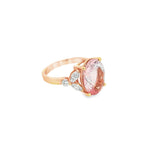 18ct rose gold ring featuring a 5.12ct oval morganite in a four-claw setting with marquise and round diamond accents and a post and bezel undercarriage.