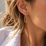 9ct yellow gold open oval drop earrings featuring polished half-dome studs, articulated elongated oval drops and butterfly fittings.
