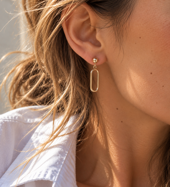 9ct yellow gold open oval drop earrings featuring polished half-dome studs, articulated elongated oval drops and butterfly fittings.