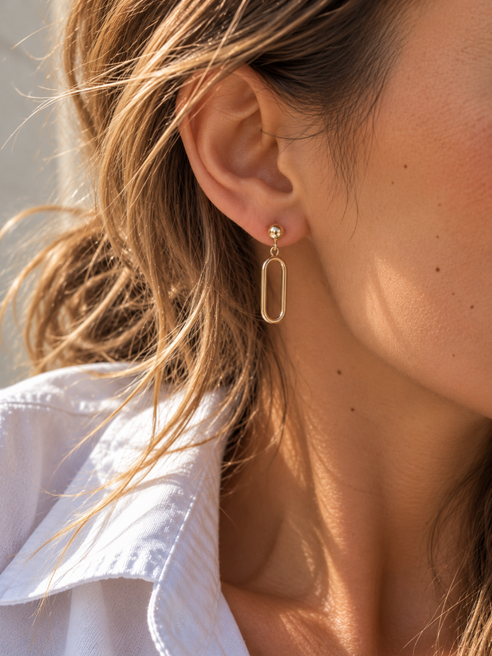 9ct yellow gold open oval drop earrings featuring polished half-dome studs, articulated elongated oval drops and butterfly fittings.