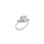 18ct white gold three stone diamond ring featuring a 2.17ct oval centre diamond with pear cut diamond side stones in tiered cap-and-claw settings.