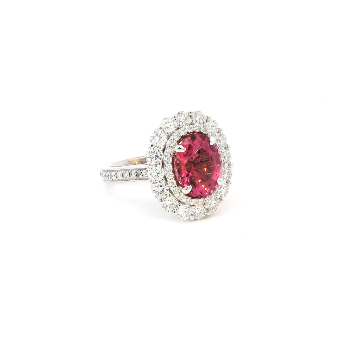 18ct white gold ring featuring a 3.66ct oval cut pink tourmaline surrounded by double diamond halos with diamond-set shoulders.