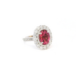 18ct white gold ring featuring a 3.66ct oval cut pink tourmaline surrounded by double diamond halos with diamond-set shoulders.
