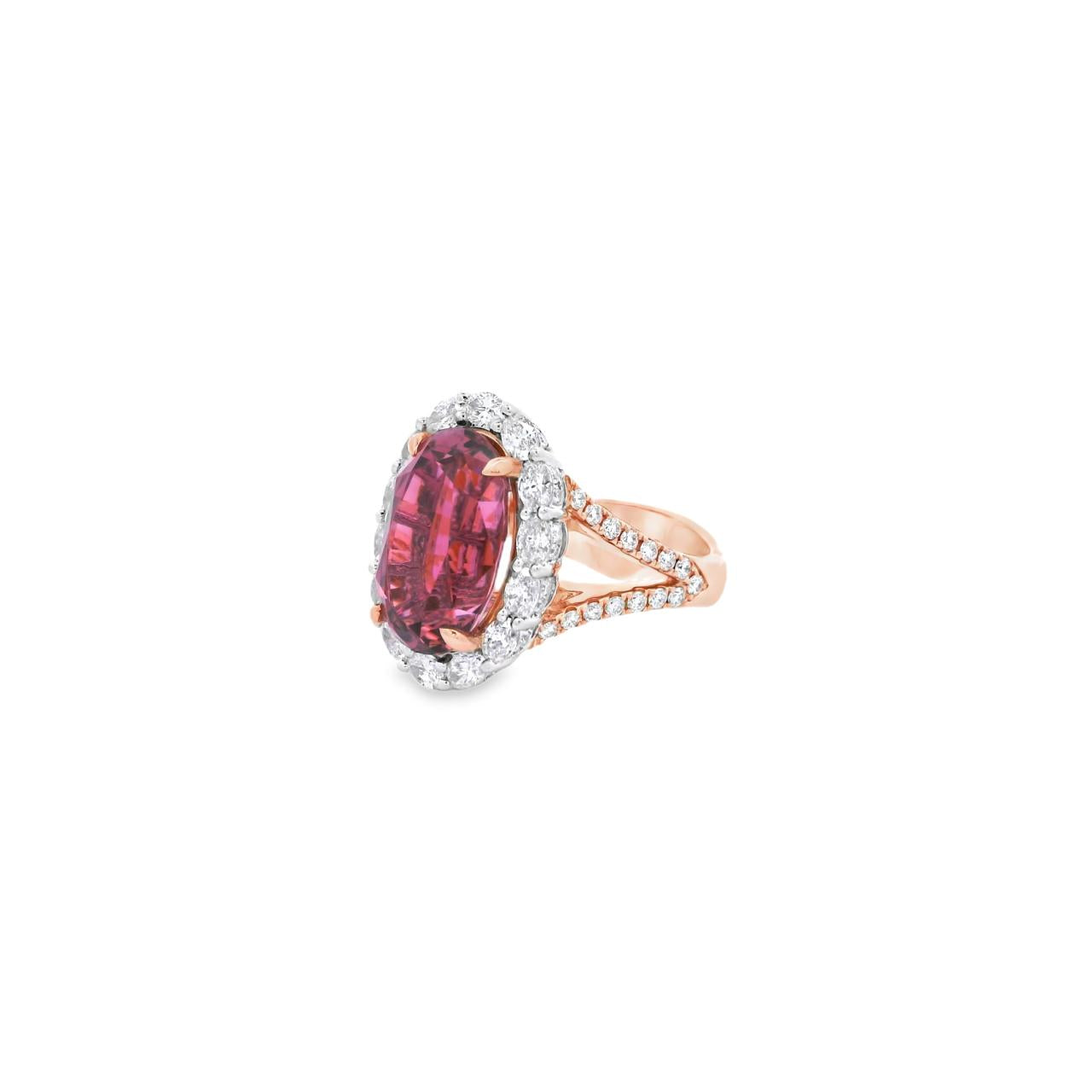 18ct rose and white gold ring featuring a 9.25ct oval pink tourmaline surrounded by a halo of diamonds, with rubies bead set into the undercarriage and split claw shoulders.