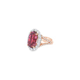18ct rose and white gold ring featuring a 9.25ct oval pink tourmaline surrounded by a halo of diamonds, with rubies bead set into the undercarriage and split claw shoulders.