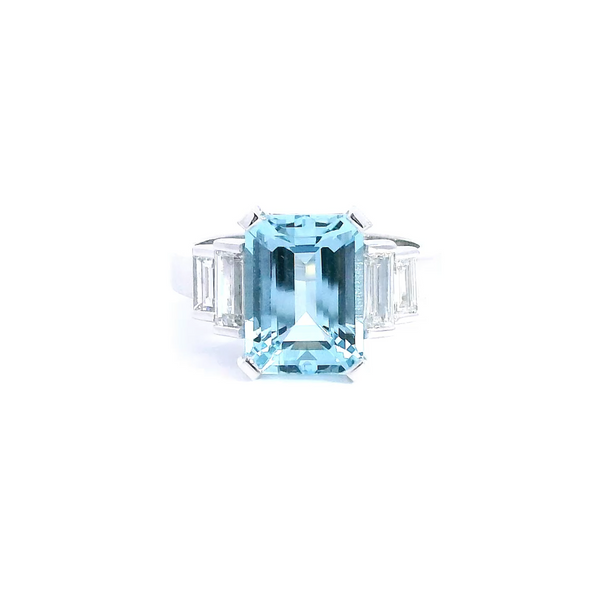 Platinum ring with emerald-cut aquamarine and stepped baguette diamond shoulders.