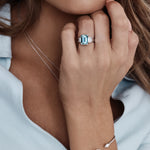 Platinum ring with emerald-cut aquamarine and stepped baguette diamond shoulders.