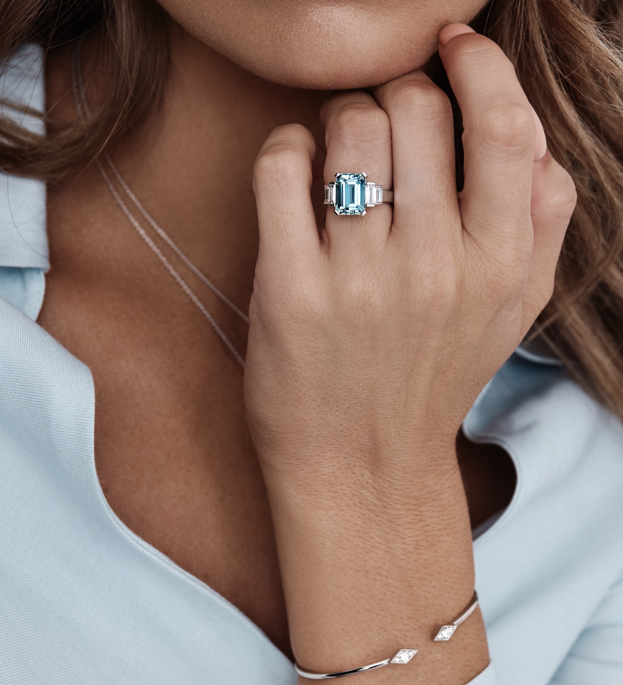 Platinum ring with emerald-cut aquamarine and stepped baguette diamond shoulders.