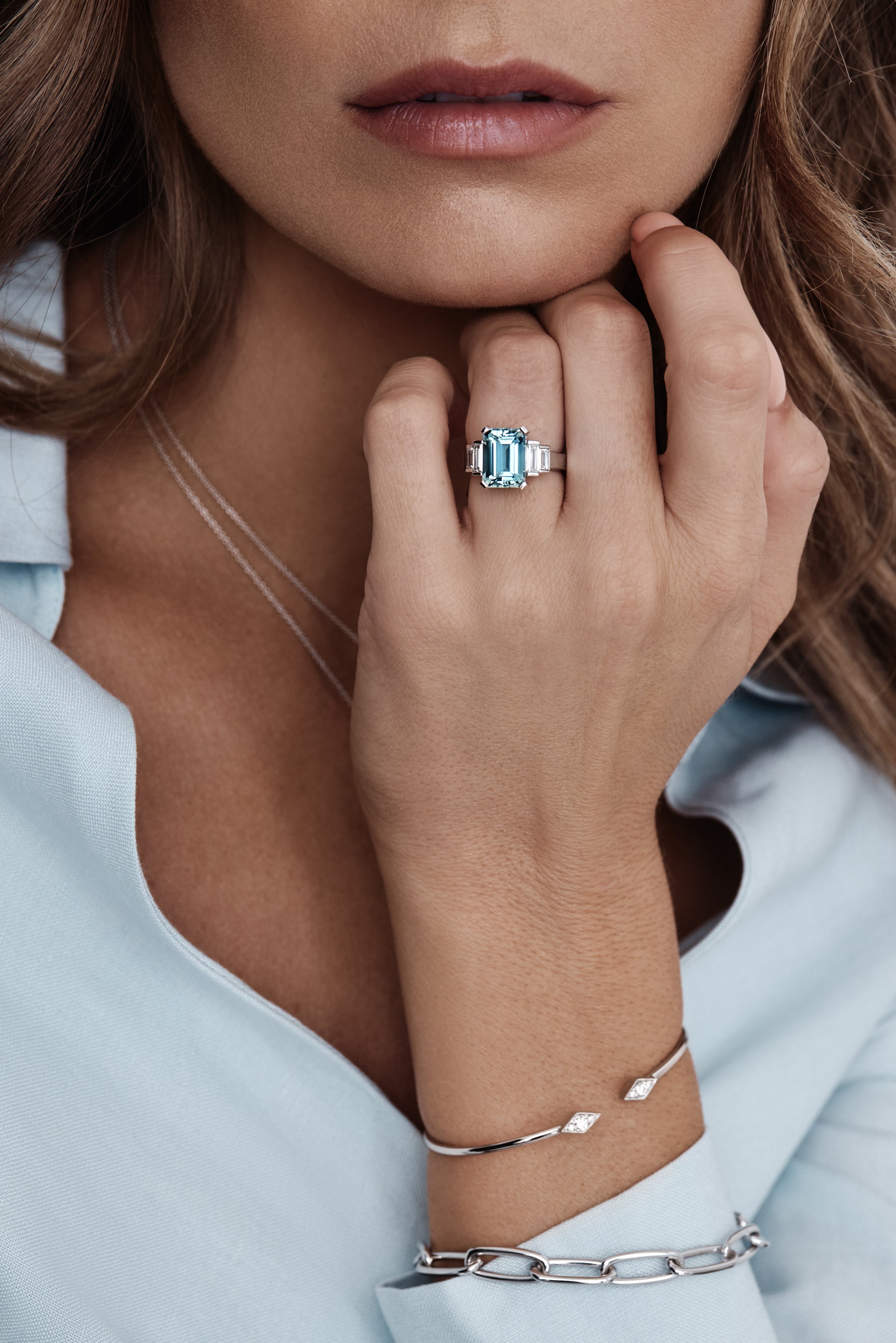 Platinum ring with emerald-cut aquamarine and stepped baguette diamond shoulders.