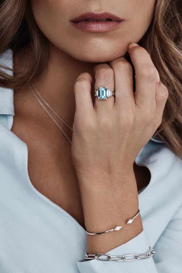 Platinum ring with emerald-cut aquamarine and stepped baguette diamond shoulders.