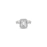 Platinum emerald cut diamond ring with halo and diamond-set shoulders.