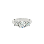 Platinum three-stone diamond ring with tiered round brilliant cut settings.