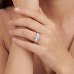 Platinum three-stone diamond ring with tiered round brilliant cut settings.