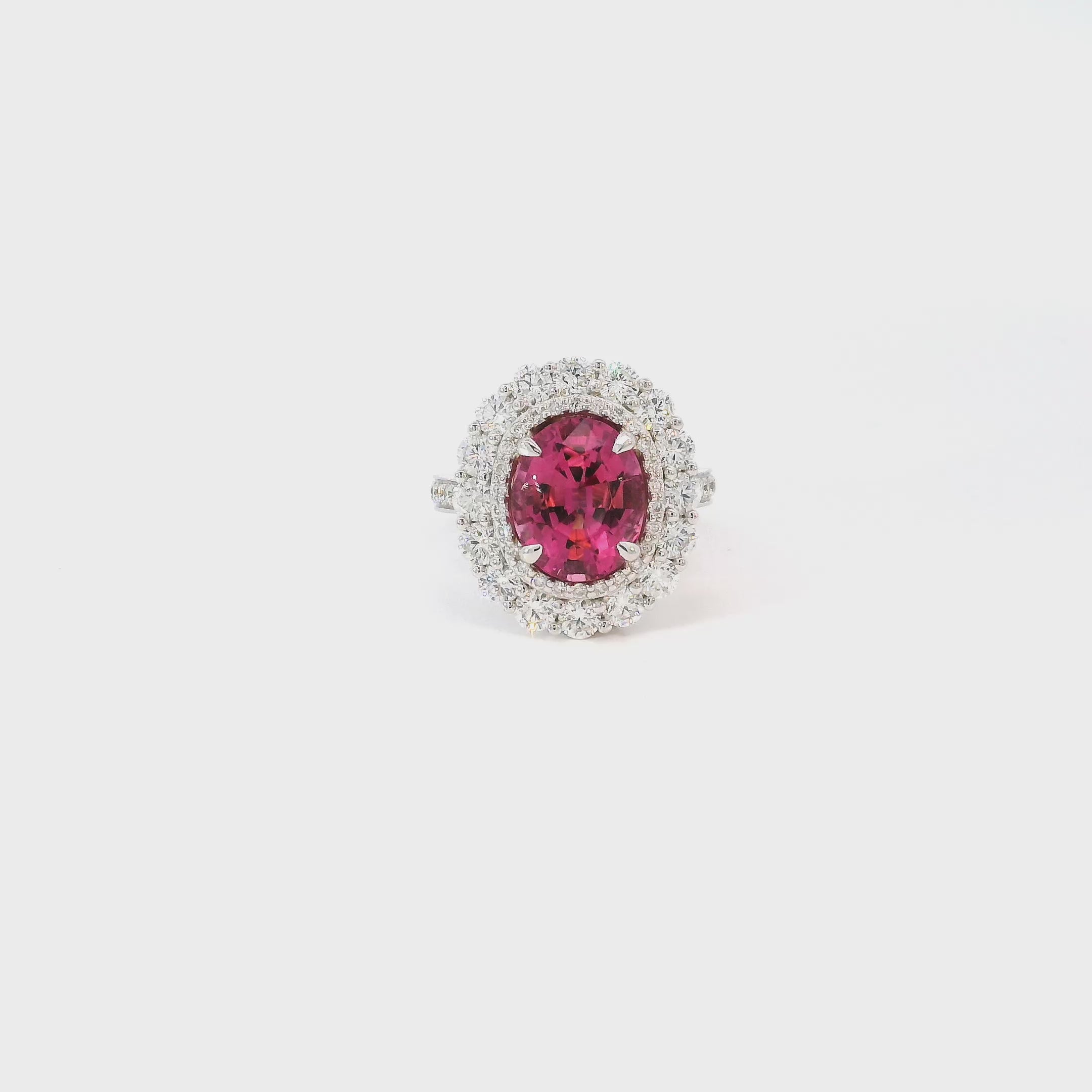 18ct white gold ring featuring a 3.66ct oval cut pink tourmaline surrounded by double diamond halos with diamond-set shoulders.