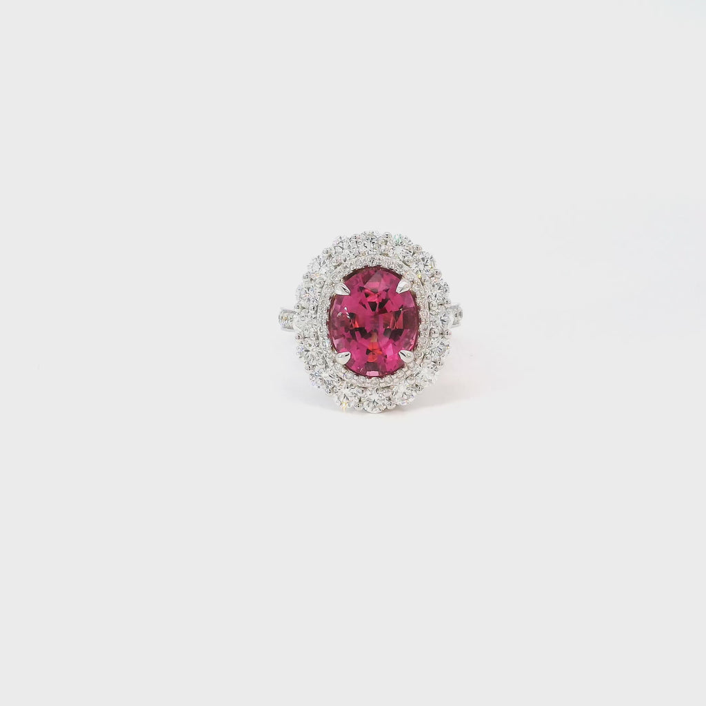 18ct white gold ring featuring a 3.66ct oval cut pink tourmaline surrounded by double diamond halos with diamond-set shoulders.