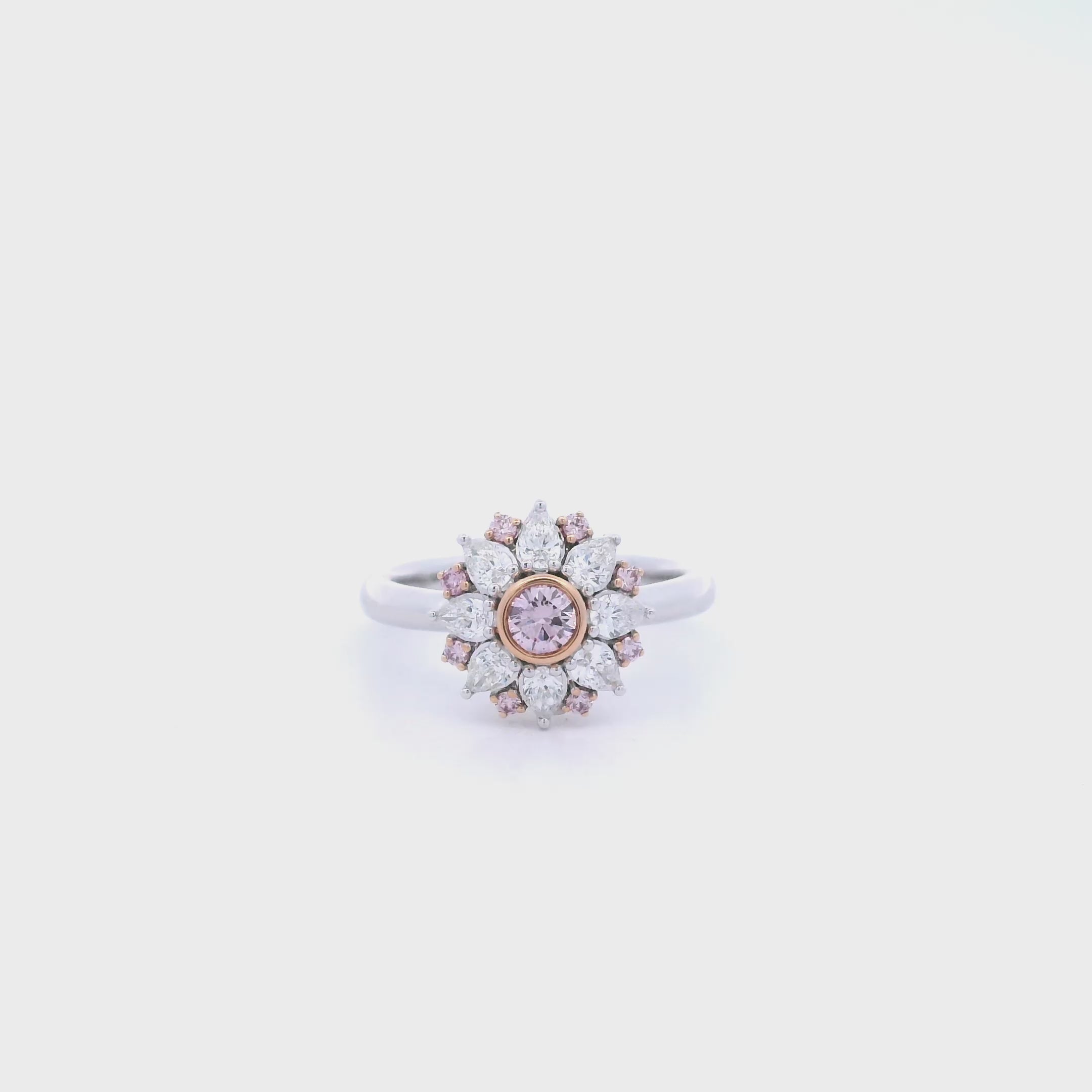 18ct white and rose gold floral ring featuring a central pink diamond, alternating pink and white diamonds, and a finely detailed cut-out back.