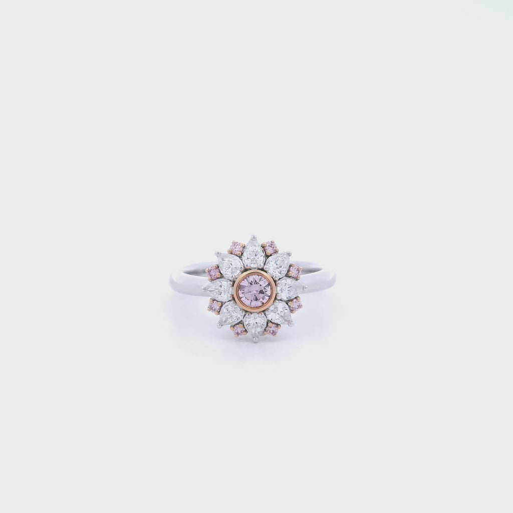 18ct white and rose gold floral ring featuring a central pink diamond, alternating pink and white diamonds, and a finely detailed cut-out back.