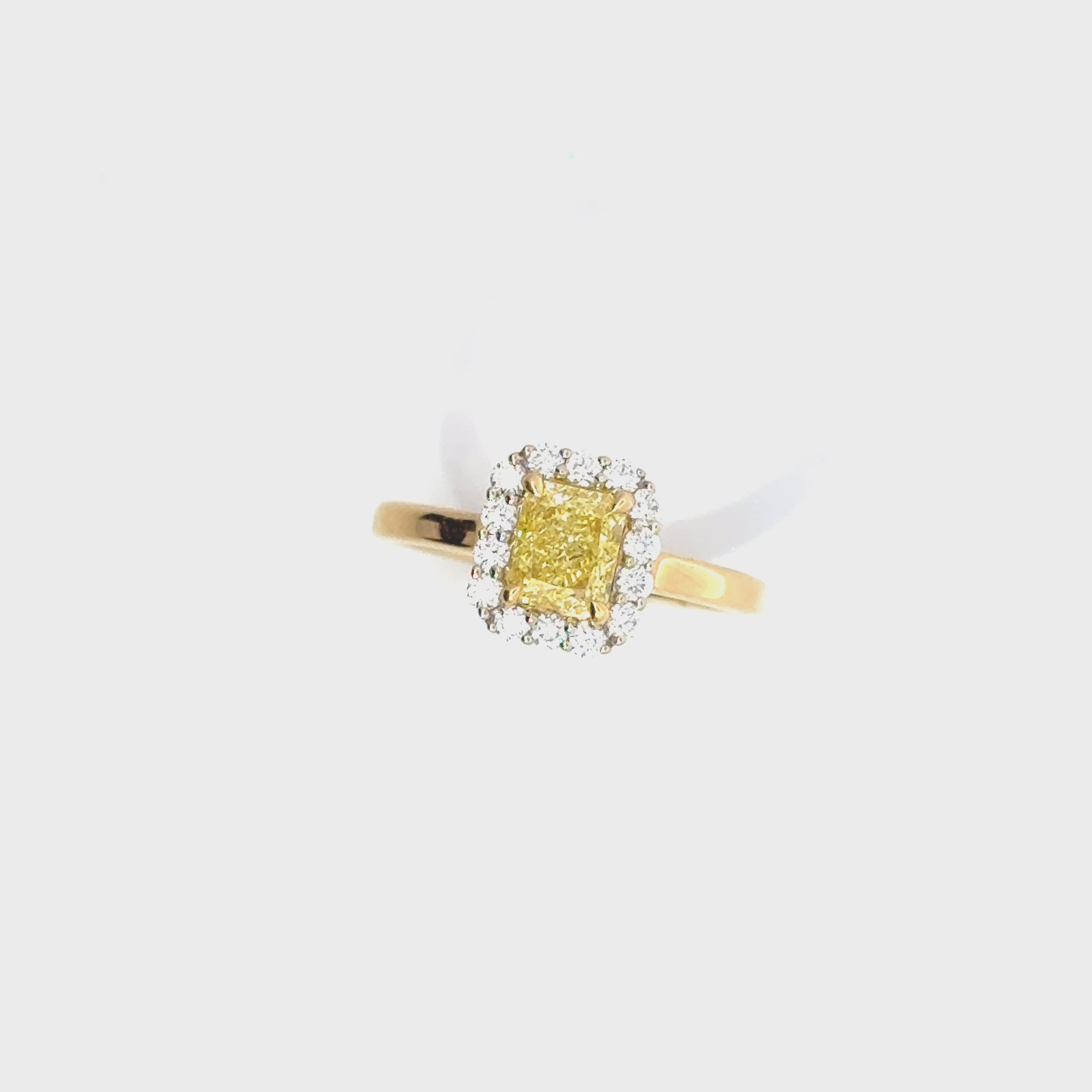 Two-tone 18ct yellow and white gold ring featuring a 1.01ct Fancy Intense Yellow radiant cut diamond with a white diamond cluster surround.