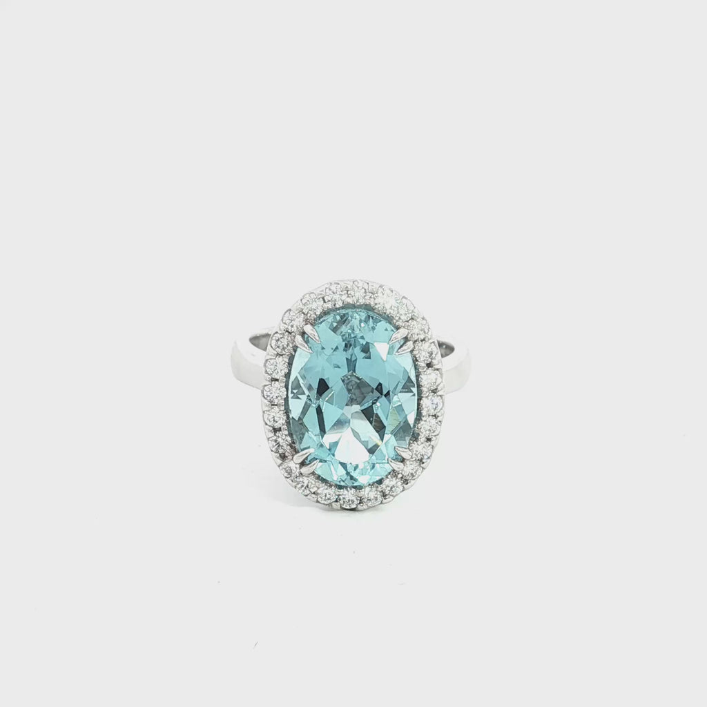 18ct white gold aquamarine and diamond halo ring featuring a 5.38ct oval aquamarine with 24 round brilliant cut diamonds, size N (resizeable).