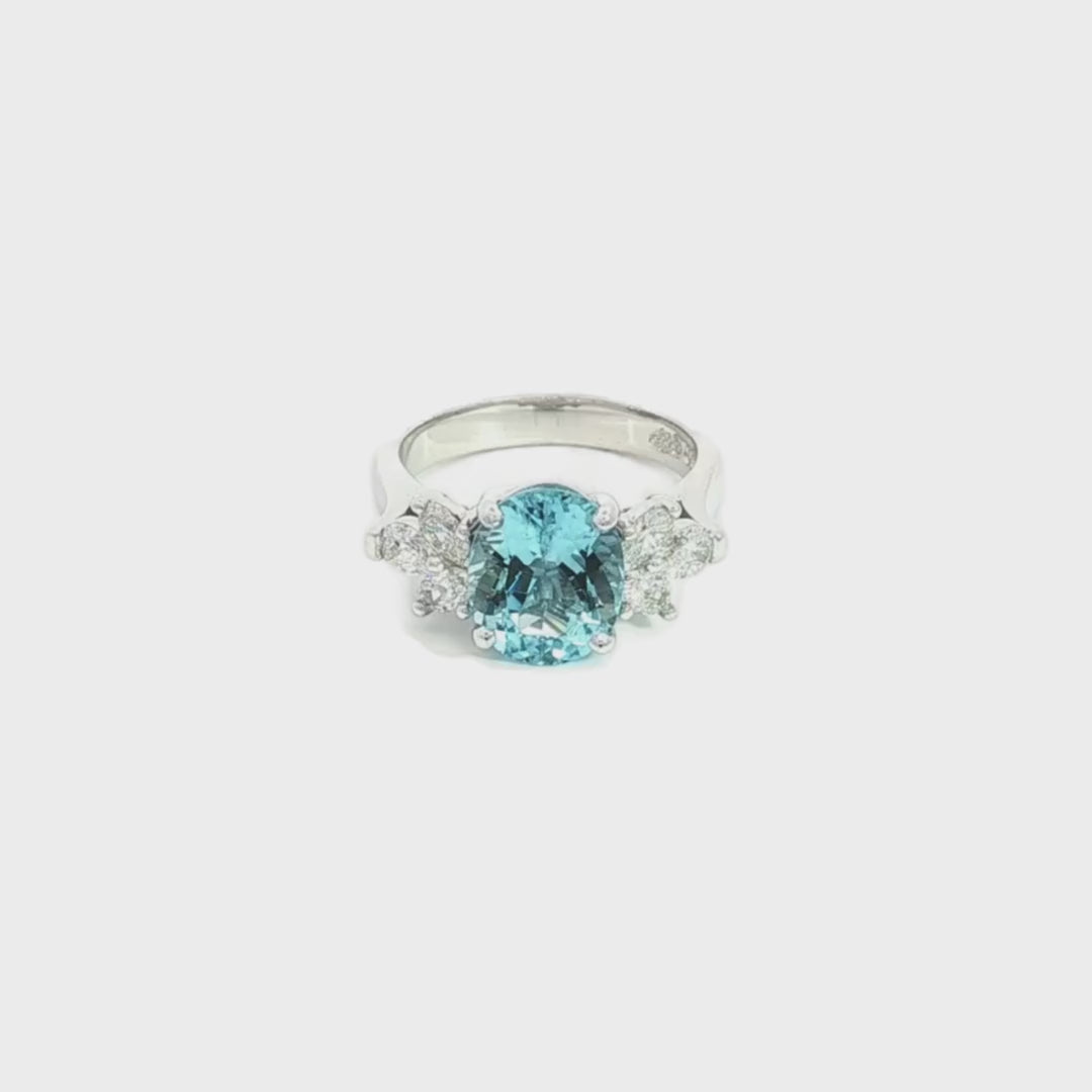 18ct white gold aquamarine and diamond cluster ring featuring a 3.22ct oval aquamarine with oval and pear-cut diamond spray clusters.