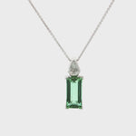 18ct white gold pendant featuring a 4.24ct rectangular cut green tourmaline and bezel-set shield diamond on a fine trace link chain.