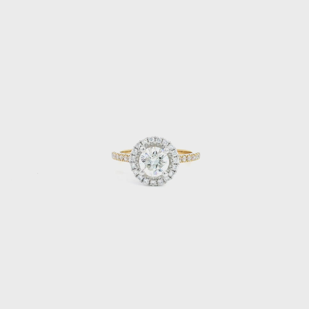 18ct yellow and white gold diamond halo ring featuring a 1.02ct round brilliant cut diamond with a multi-claw halo and diamond-set shoulders.