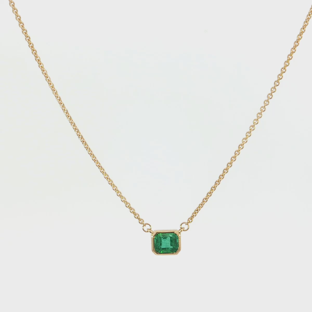 18ct yellow gold necklace with emerald cut emerald set horizontally in bezel