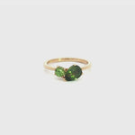 9ct yellow gold “Toi et Moi” ring featuring a 1.22ct pear cut and 0.32ct round green sapphire in angled claw settings with post and bezel collets.