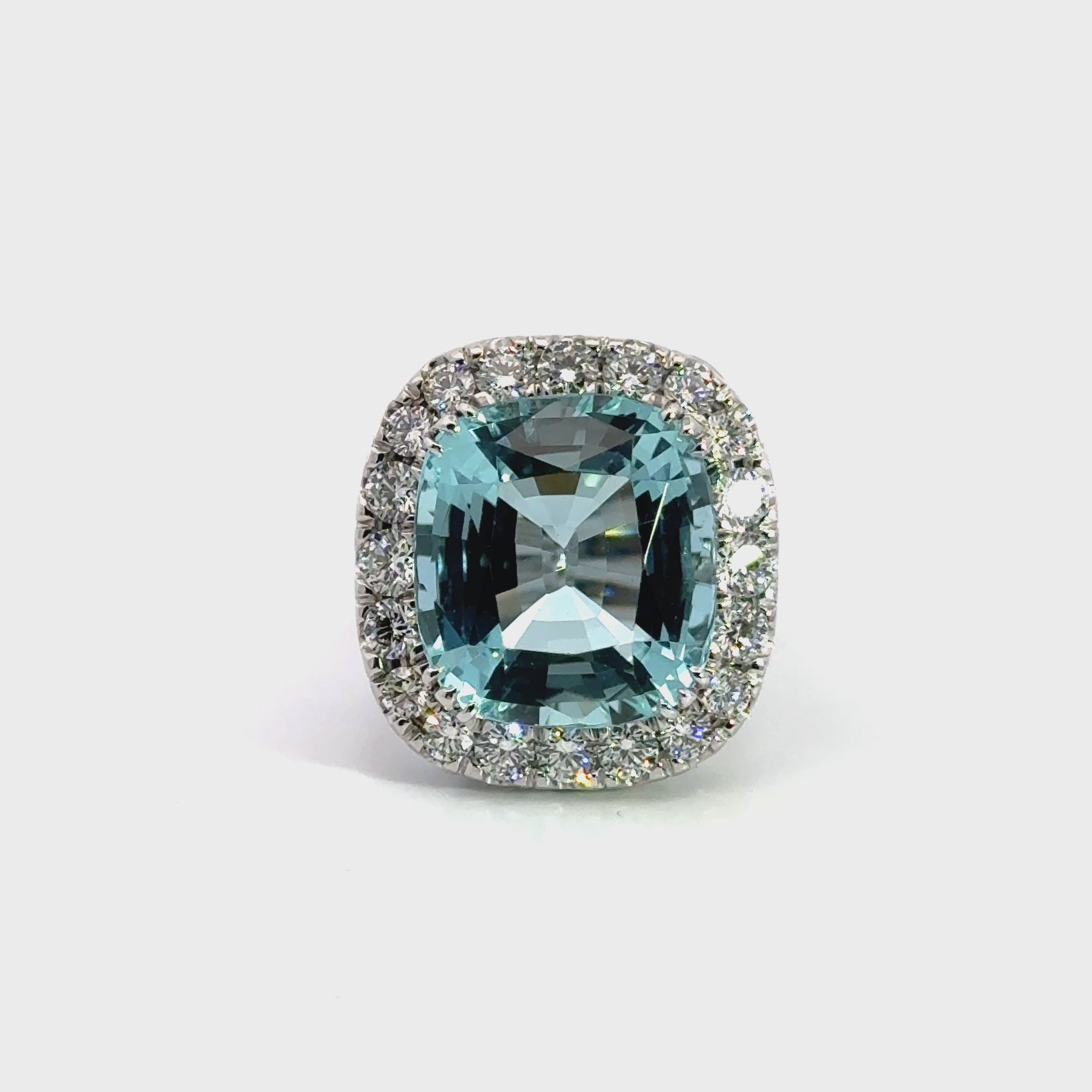 18ct white gold aquamarine and diamond ring featuring a 15.77ct cushion cut aquamarine surrounded by a cushion-shaped diamond halo.