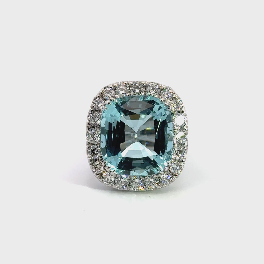 18ct white gold aquamarine and diamond ring featuring a 15.77ct cushion cut aquamarine surrounded by a cushion-shaped diamond halo.