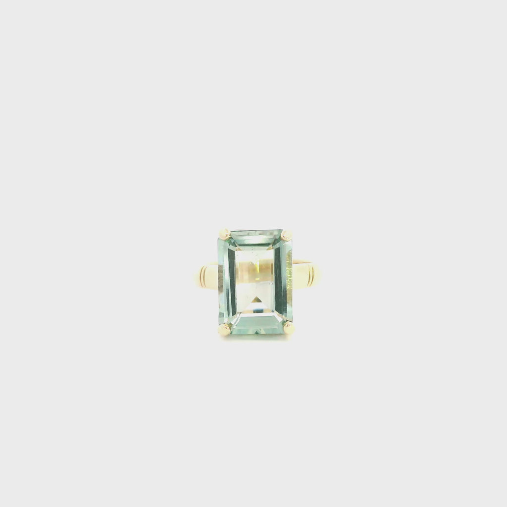 9ct yellow gold ring featuring a 14 x 10mm emerald cut green quartz in a four-claw setting with engraved shoulders.