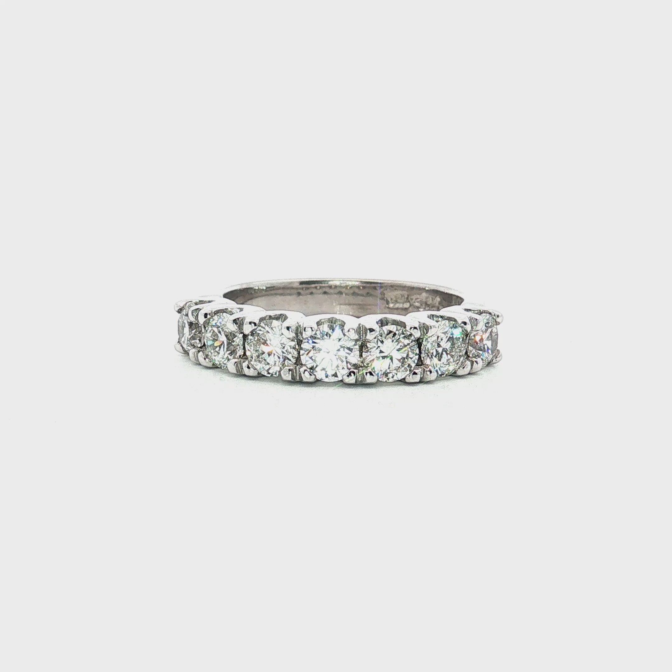 18ct white gold ring featuring seven round brilliant cut diamonds totalling 1.38ct in a straight row shared claw setting with curved undercarriage.