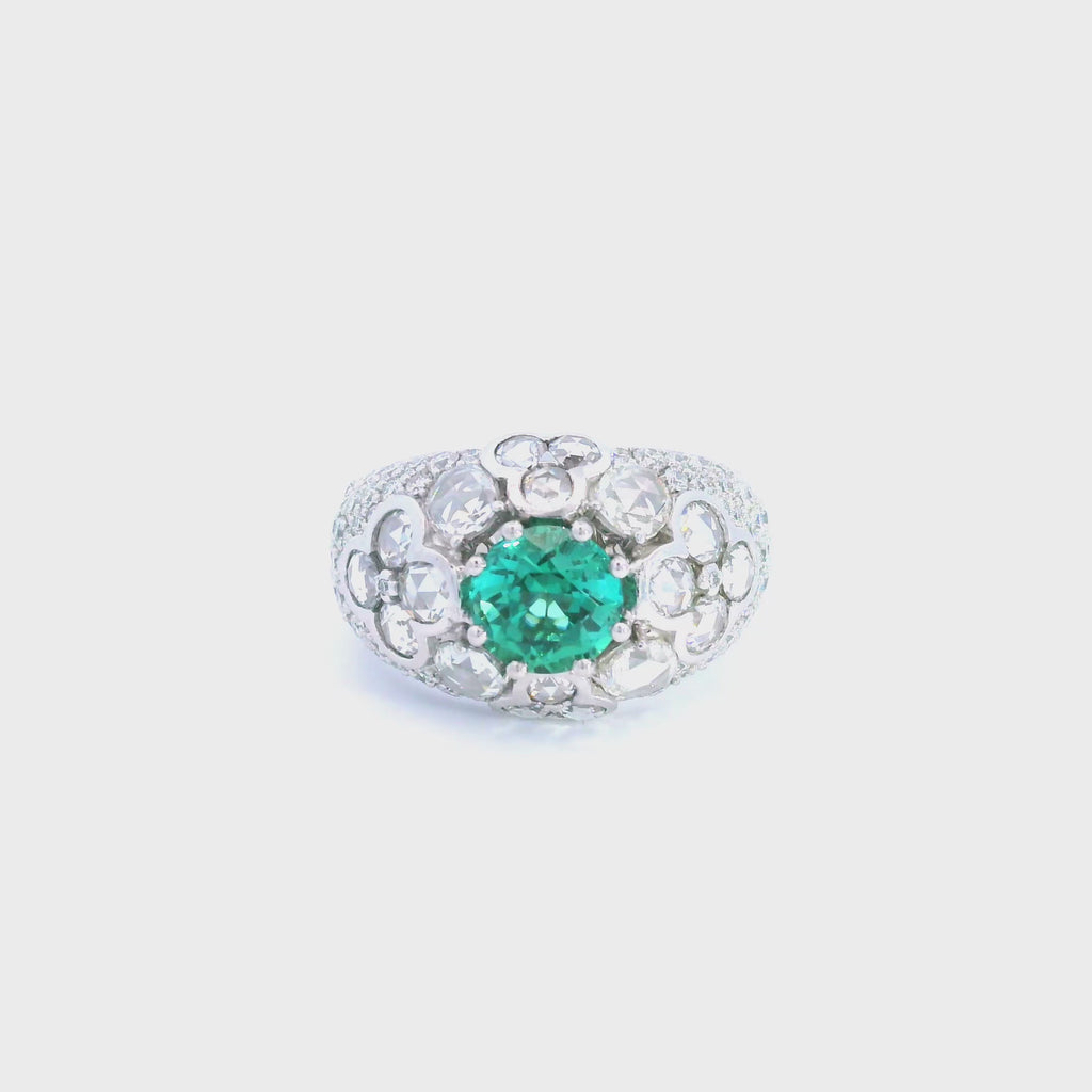 18ct white gold domed ring featuring a teal tourmaline with rose cut and round brilliant cut diamond floral clusters and pavé-set shoulders.