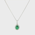 18ct white gold emerald and diamond pendant with oval emerald and halo design