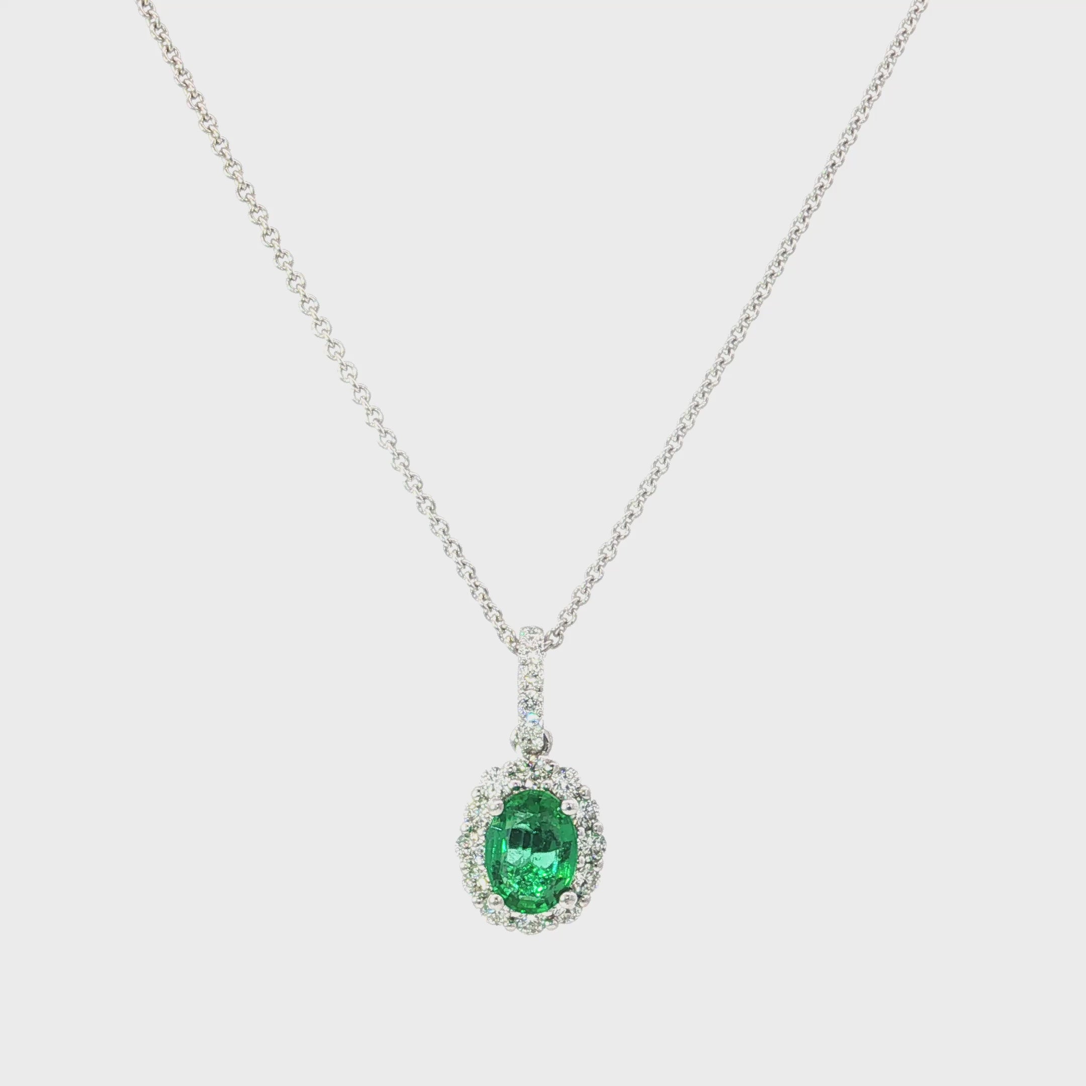 18ct white gold emerald and diamond pendant with oval emerald and halo design