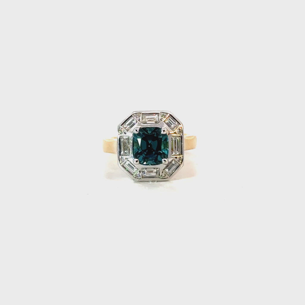 18ct yellow and white gold ring featuring a 1.88ct cushion cut greenish-blue tourmaline surrounded by baguette and round brilliant cut diamonds in an octagonal cluster design.