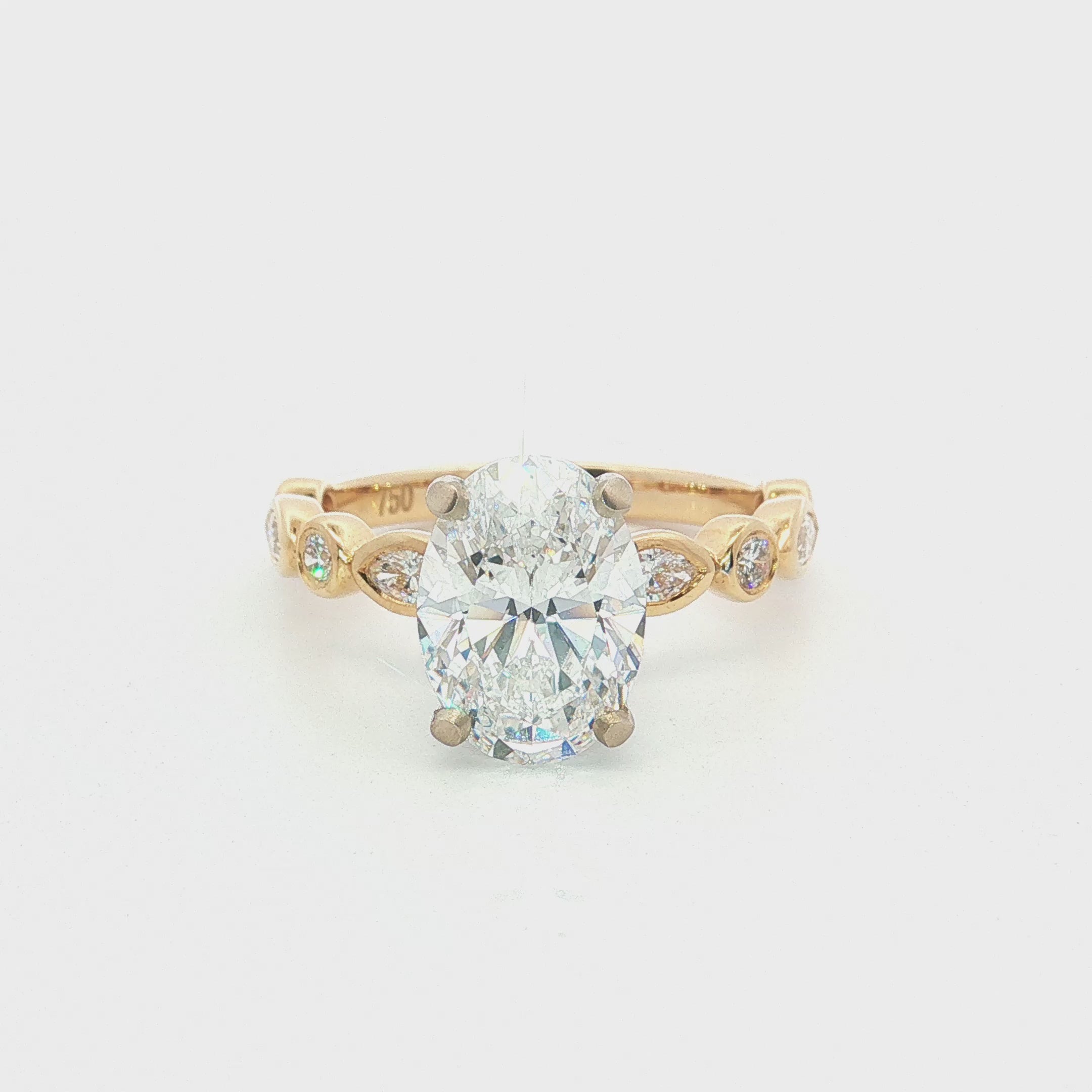 Side view of 2.50ct oval diamond engagement ring showing the white gold centre setting and yellow gold diamond-set shoulders.