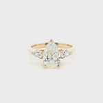 Three-stone pear diamond engagement ring in 18ct yellow gold with vertically set centre diamond and horizontal pear-shaped side stones.