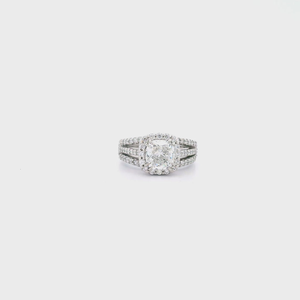 Platinum cushion cut diamond halo ring featuring a 2.00ct centre diamond with a halo surround and triple split diamond-set shoulders.