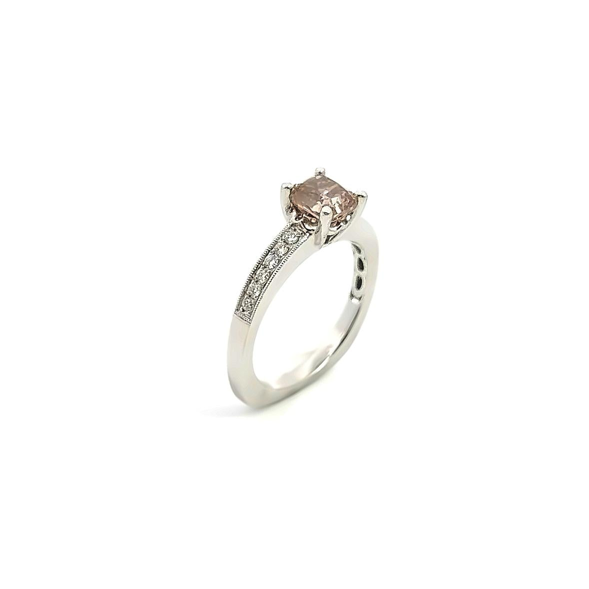 Platinum ring featuring a 1.21ct radiant cut champagne diamond with bead-set round brilliant cut diamond shoulders and millgrain detailing.