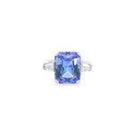 18ct white gold ring featuring a 6.99ct radiant cut tanzanite with two tapered baguette cut diamonds in a tiered three-stone setting.