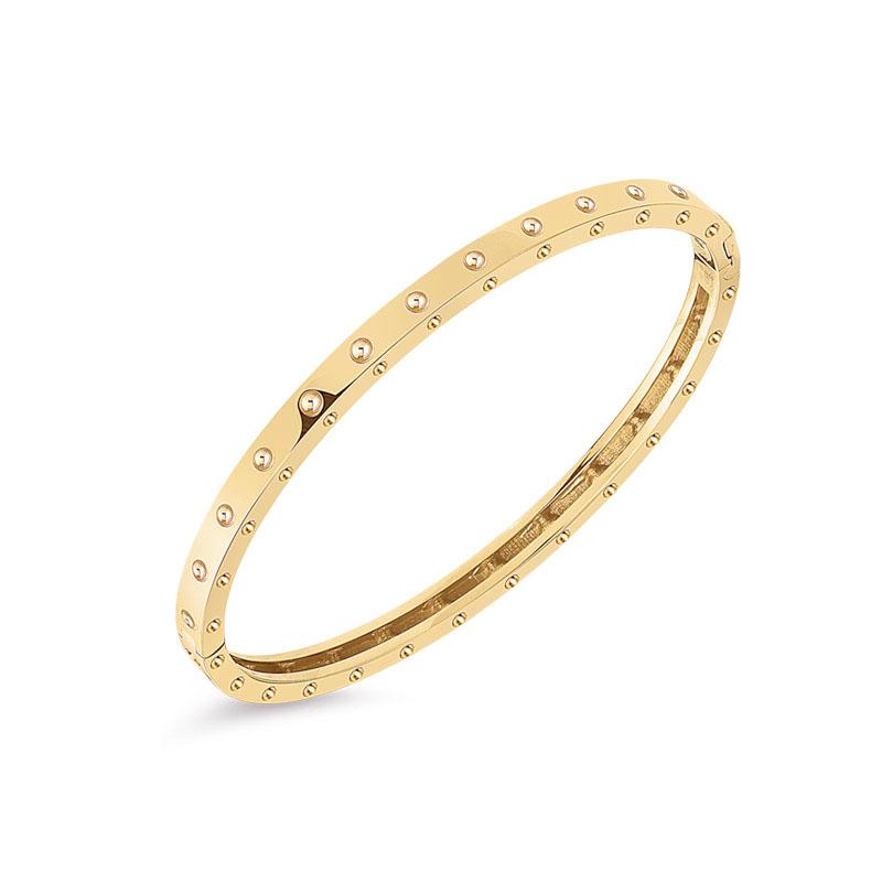 Roberto Coin Pois Moi 18ct yellow gold diamond bangle featuring polished dimple pattern on top and sides, with signature hidden ruby set inside.