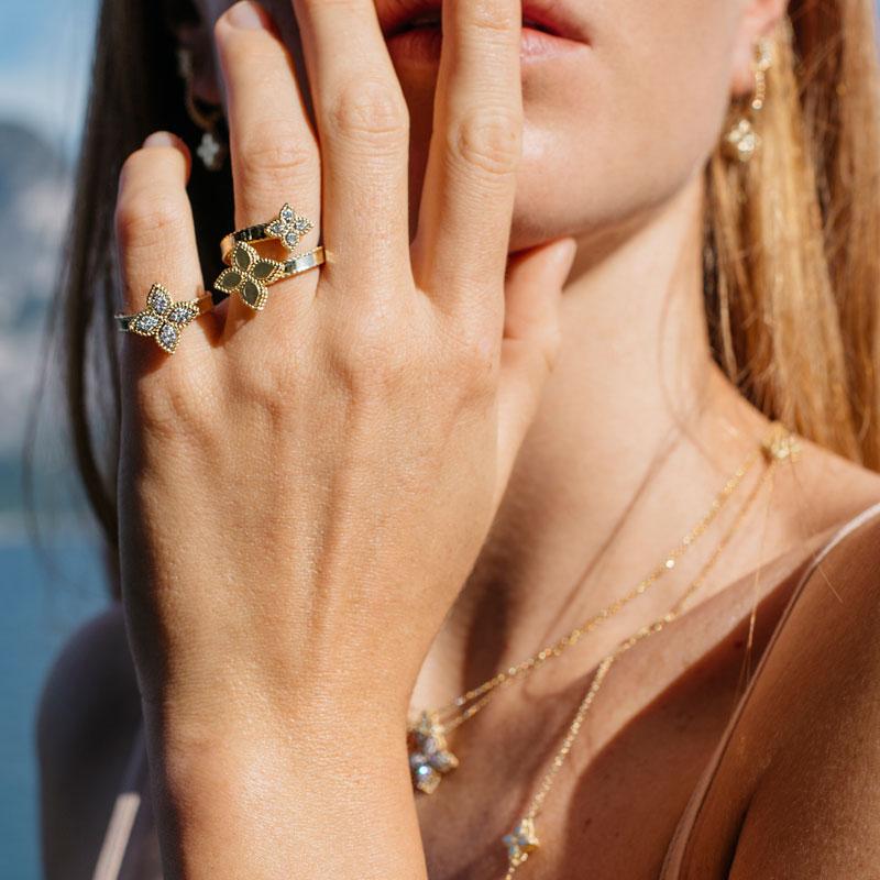 Roberto Coin Princess Flower ring in 18ct yellow and white gold featuring four diamond cluster petals, rope edge detailing, and a signature hidden ruby inside the band.
