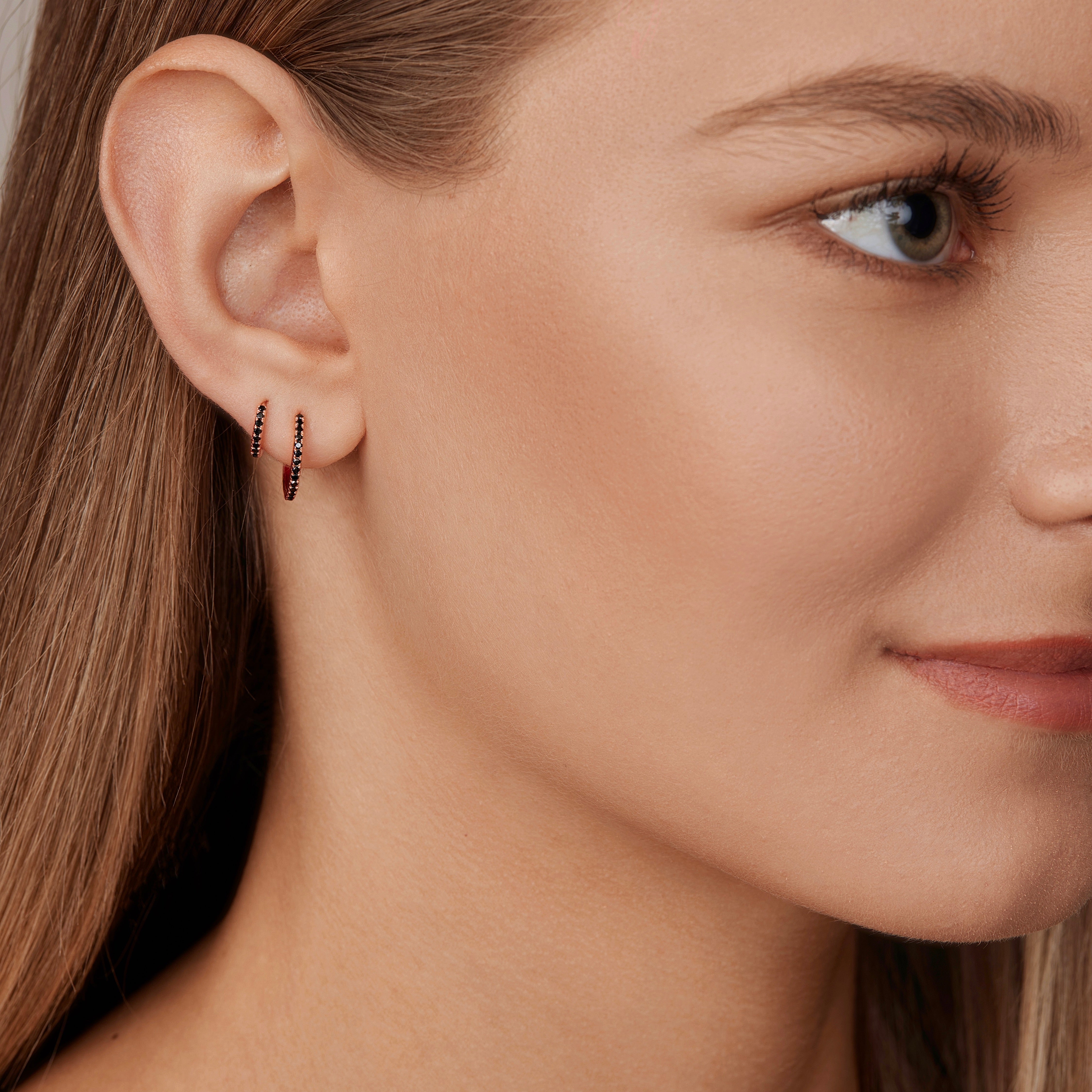 18ct rose gold black diamond huggie earrings with claw-set black diamonds around the front and inside back.